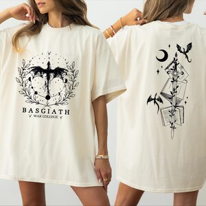 two women wearing white t-shirts with black designs on the back.