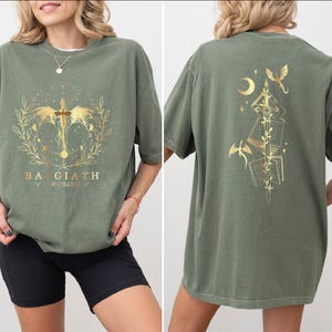 a woman wearing a green t-shirt with a gold design on the front and back.