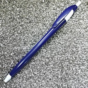 May include: A blue and white ballpoint pen on a silver background.