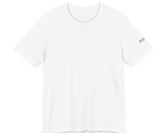 May include: A plain white short-sleeved t-shirt with a crew neckline. The shirt features a small, black, gothic-style text graphic printed on the outer edge of the left sleeve, displaying the letters MIR.