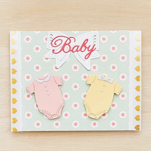 Babykaart l 2 rompertjes roze en geel l Gebloemde achtergrond l Gouden hartenrand l Uniek l Uniek l Gratis verzending in de VS