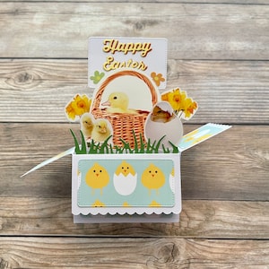 Biglietto di Pasqua pop-up 3D con scatola l Tema pulcini l Cestino con pulcini, narcisi e uova l Giallo, bianco e blu l Si piega in piano per la spedizione l Spedizione gratuita negli Stati Uniti