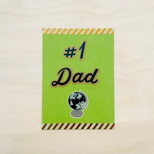 Biglietto d'auguri per la festa del papà l Papà n. 1 al mondo l Buona festa del papà l Strisce verdi e dorate l Interno vuoto l Spedizione gratuita negli Stati Uniti
