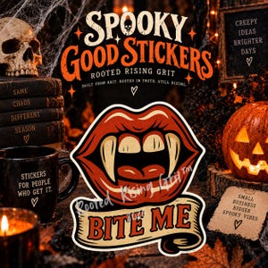 Könnte beinhalten: Ein Aufkleber mit einem Paar roter Lippen mit spitzen weißen Fangzähnen und einem Banner darunter mit dem Text BITE ME. Das Design enthält ein Totenkopf-Symbol im Wort SPOOKY und den Text ROOTED RISING GRIT BUILT FROM GRIT. ROOTED IN TRUTH. STILL RISING.