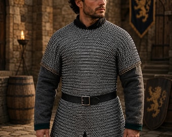 May include: A medieval chainmail shirt with a black leather belt and buckle. The shirt is worn over a gray long-sleeved garment. The background includes a stone building, wooden barrels, and a banner with a gold lion emblem.