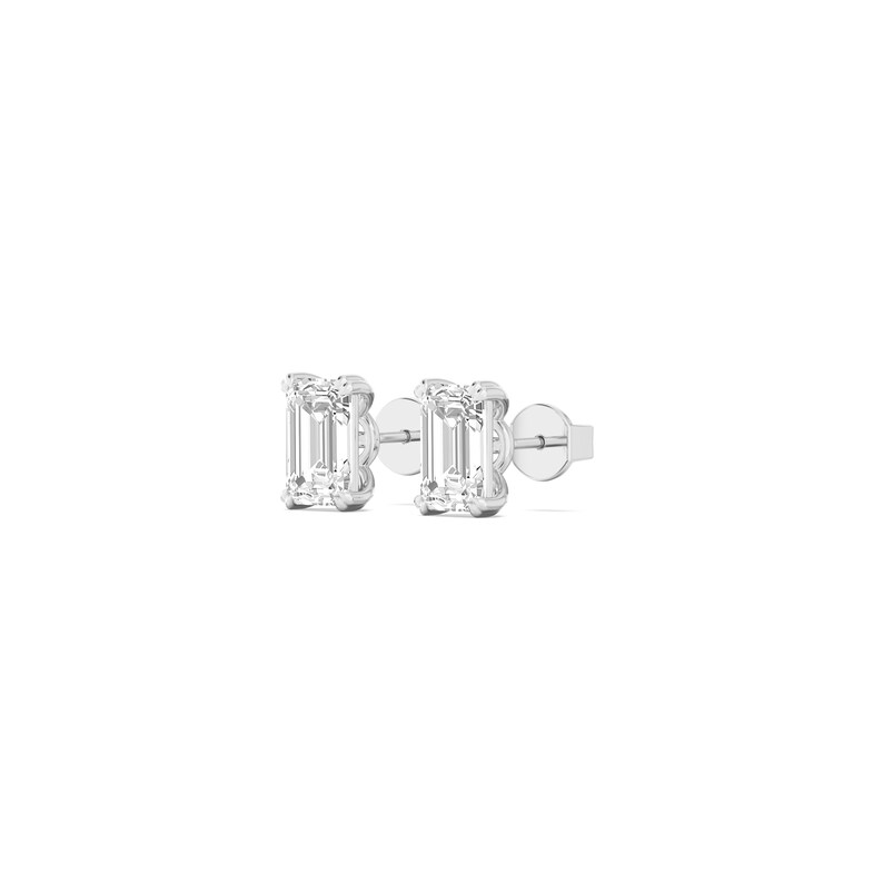 May include: A pair of silver stud earrings featuring rectangular, clear gemstones. The earrings are set in a simple, minimalist design, with a post and backing for secure wear. The gemstones have a brilliant cut, reflecting light.