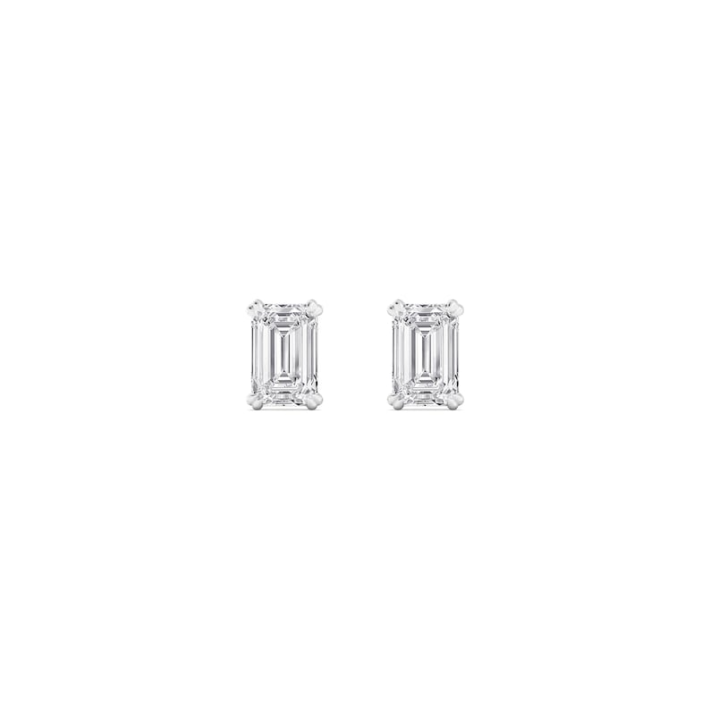 May include: A pair of stud earrings featuring emerald-cut diamonds. The diamonds are set in a white metal, likely platinum or white gold, and are displayed against a white background. The earrings are a classic jewelry item.