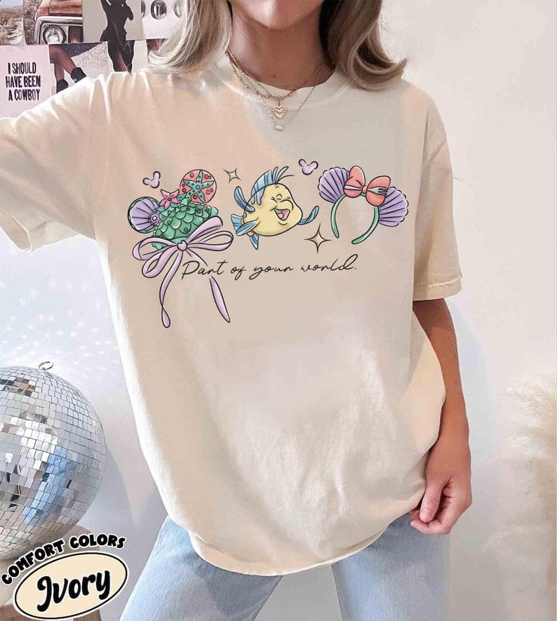 May include: A white ceramic mug with a black handle and the text "But First, Coffee" in a bold, black font. The mug is set against a blurred background, suggesting a cosy setting.