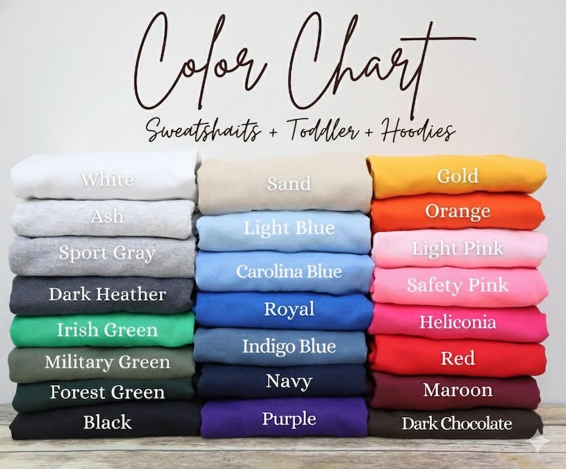 May include: Color chart for sweatshirts, toddler, and hoodies. The chart displays a variety of colors, including white, ash, sport gray, dark heather, Irish green, military green, forest green, and black. Other colors include sand, light blue, Carolina blue, royal, indigo blue, navy, and purple. Additional colors are gold, orange, light pink, safety pink, heliconia, red, maroon, and dark chocolate.