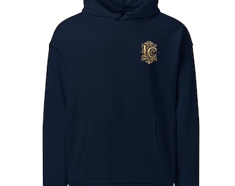 May include: A navy blue hoodie with a front pocket and a hood. The hoodie features a gold-colored emblem on the upper left chest. The emblem appears to be a monogram with ornate detailing. The hoodie is made of a soft material.