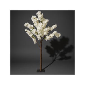 May include: A faux cherry blossom tree with white flowers and a brown trunk. The tree is set on a black square base. The tree's shadow is cast on a dark gray background.