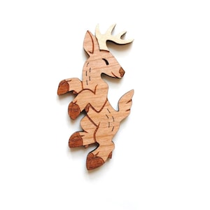 May include: A wooden cutout of a brown deer with antlers, standing on its hind legs. The deer has a simple, cartoon-like design.