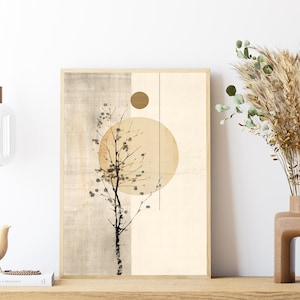May include: A framed abstract art print featuring a beige and tan color palette with a stylized tree branch and a large circle. A decorative vase with dried plants and a wooden bird figurine are also visible.