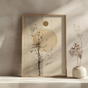 May include: A framed abstract art print featuring a stylized tree silhouette with a large circular shape and a smaller circle. The artwork is in neutral tones of beige, brown, and black, with a minimalist aesthetic. A small vase with dried flowers is in the foreground.