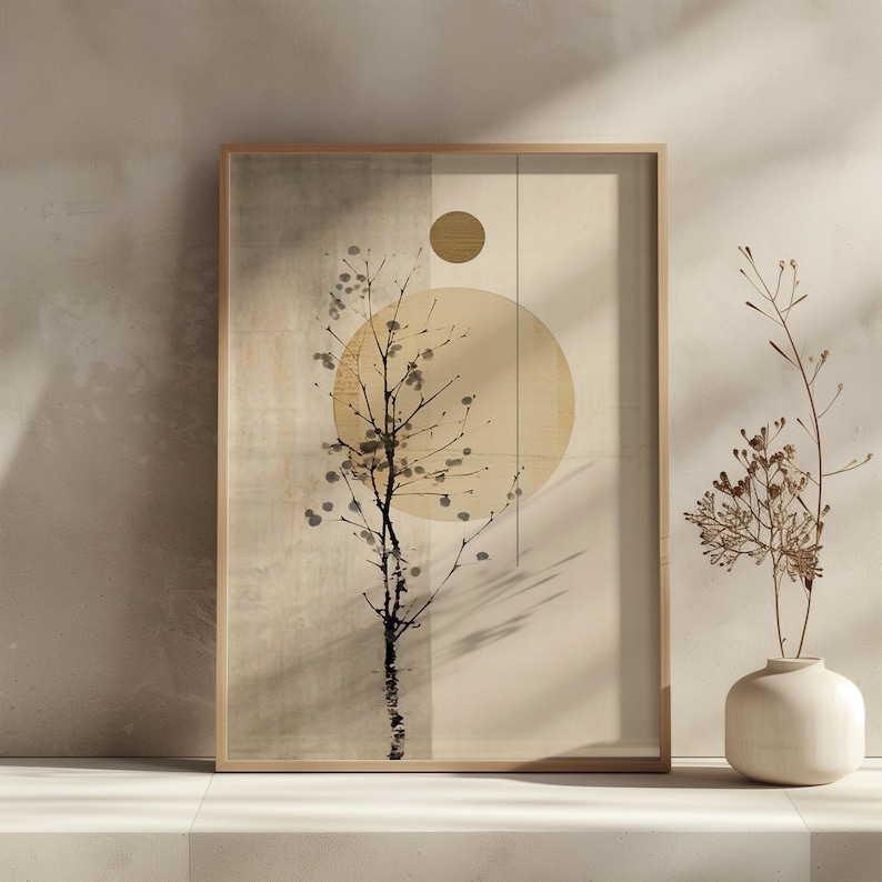 May include: A framed abstract art print featuring a stylized tree silhouette with a large circular shape and a smaller circle. The artwork is in neutral tones of beige, brown, and black, with a minimalist aesthetic. A small vase with dried flowers is in the foreground.