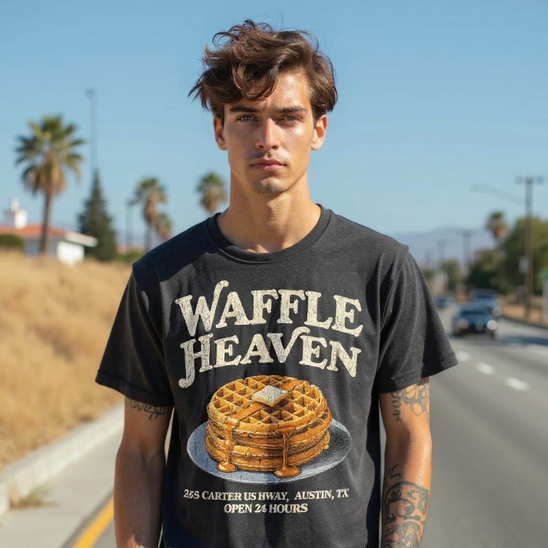 May include: Dark gray t-shirt with the text "WAFFLE HEAVEN" above a waffle graphic with butter and syrup. Below the graphic is the text "265 CARTER US HWY, AUSTIN, TX OPEN 24 HOURS".