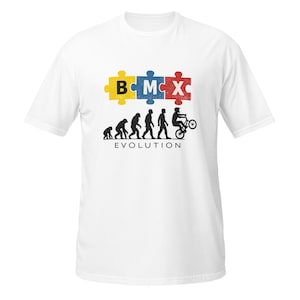 Può includere: T-shirt bianca con un design BMX. Il design include la parola "BMX" in pezzi di puzzle e una silhouette dell'evoluzione dell'uomo a un ciclista BMX. La parola "EVOLUTION" è stampata sotto.