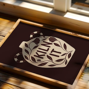 May include: A rectangular framed print featuring a dark brown background and a central cream-colored amphora illustration. The amphora is decorated with dark brown leaf patterns and contains the text KILN IT in bold, dark brown capital letters.