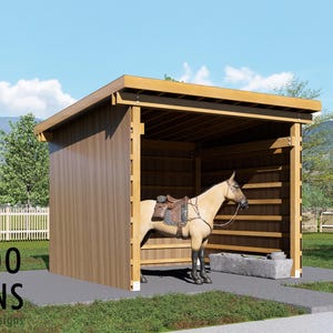 Puede incluir: Un refugio de madera para caballos con techo plano y frente abierto, que alberga un caballo beige con silla de montar. La estructura tiene revestimiento vertical marrón y vigas horizontales. El texto BAMBOO DESIGNS Home Plans & Designs es visible.