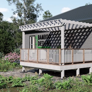 May include: A wooden deck with a pergola, featuring the text "BAMBOO DESIGNS". The deck has a white railing and is surrounded by greenery and flowers. The structure is attached to a gray building with a dark roof.