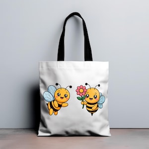 May include: White tote bag featuring two cartoon bees. One bee is flying with blue wings, and the other holds a pink flower. The bees are yellow and black with smiling faces. The bag has black handles.