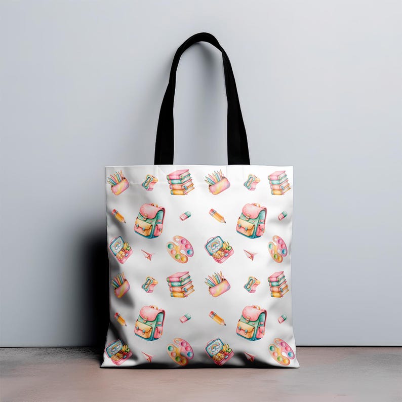 Puede incluir: Bolso tote blanco con un patr&oacute;n repetido de ilustraciones de art&iacute;culos escolares en acuarela. El dise&ntilde;o incluye mochilas, l&aacute;pices, paletas de pintura, libros y estuches en colores pastel. Tiene asas negras.
