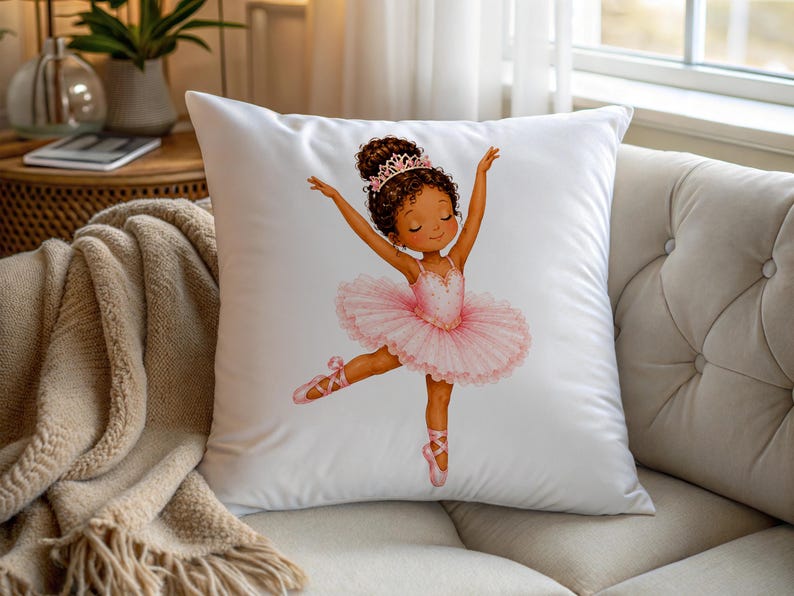 May include: A square white throw pillow featuring a centered illustration of a young ballerina with dark curly hair in a bun, wearing a pink tiara and a layered pink tutu with matching ballet slippers, posed with arms raised in a graceful dance.