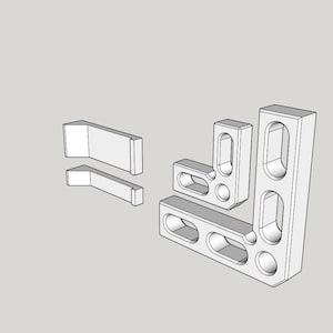May include: A collection of white, geometric shapes, possibly components or building blocks, arranged against a neutral background. The shapes include rectangular and L-shaped pieces with rounded openings, suggesting a modular or interlocking design.