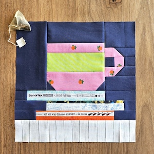 Peut inclure: Un bloc de tissu bleu et rose avec un motif de tasse à thé. Le bloc de tissu fait partie d'un projet de courtepointe appelé "Secret Garden" par Cora's Quilts. Le bloc de tissu comprend également le texte "Not all who wander are lost - J.R.R. Tolkien".