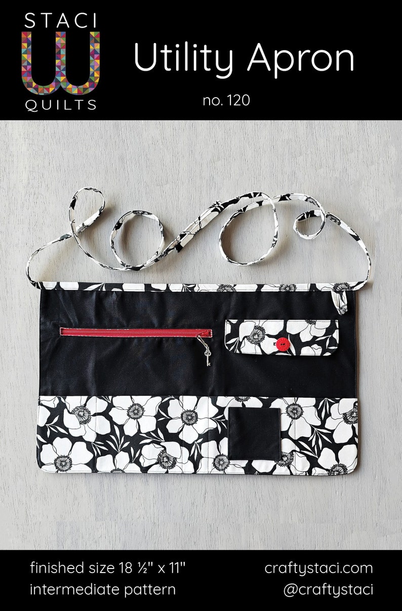 May include: Black and white utility apron with a floral print and multiple pockets. The apron has a red zipper pocket and a black fabric loop for hanging. The apron measures 18 1/2 inches by 11 inches.  The text "STACI QUILTS" and "Utility Apron no. 120" is printed on the image.