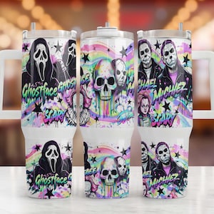 May include: A white stainless steel tumbler with a handle and lid, featuring a colorful graphic print of horror movie characters including Ghostface, Michael Myers, and Chucky, alongside skulls, black stars, and the text Ghostface and Michiez.