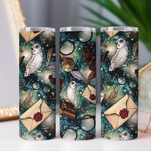 May include: Three tall, cylindrical tumblers featuring a repeating pattern of owls, envelopes, feathers, and spectacles on a teal and gold background. The design has a magical theme, ideal for fantasy literature fans.