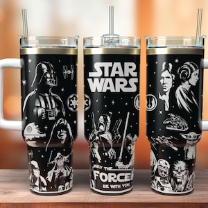 May include: A black stainless steel tumbler with a white handle and straw, featuring a wrap-around Star Wars graphic. The design includes illustrations of Darth Vader, Han Solo, Princess Leia, and other characters with the text Star Wars May The Force Be With You.