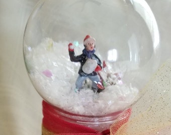 Un garçon de boule à neige sans eau lance des boules de neige