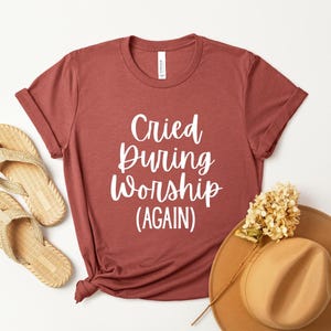 Puede incluir: Una taza de cerámica blanca con un asa negra y el texto "But First, Coffee" en un estilo manuscrito. La taza está sobre una superficie blanca. La taza mide aproximadamente 10 cm de alto.