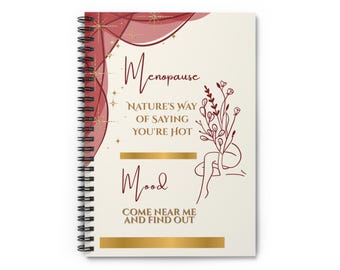 Puede incluir: Un cuaderno con espiral y cubierta crema. La portada presenta la palabra "Menopause" en escritura burdeos, junto con las frases "Nature's Way of Saying You're Hot" y "Mood". También hay un dibujo lineal de una persona y elementos florales.