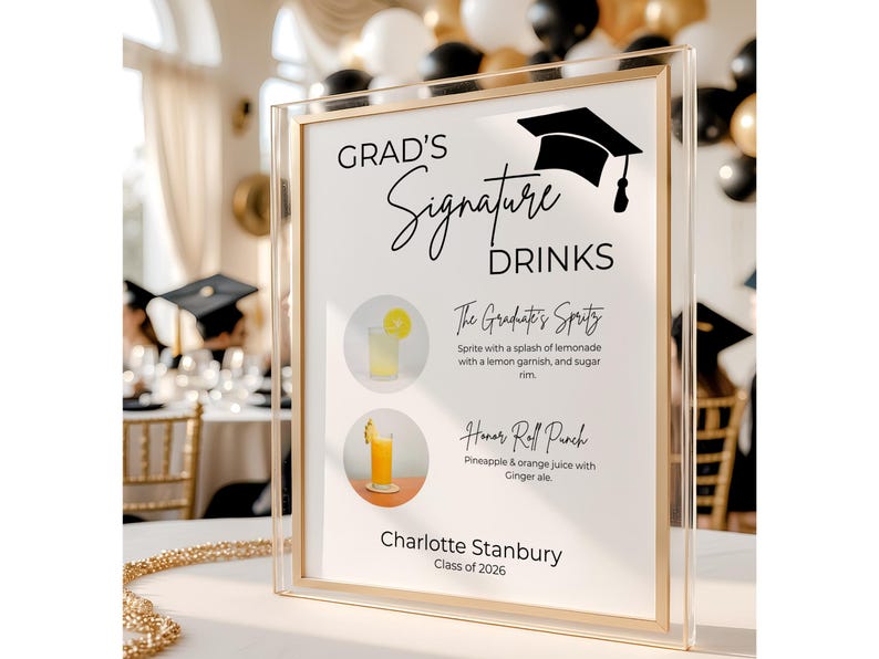 May include: A clear acrylic sign with a gold frame featuring the text Grad's Signature Drinks, a graduation cap icon, and two drink illustrations. The sign lists The Graduate's Spritz and Honor Roll Punch, with the name Charlotte Stanbury and Class of 2026.