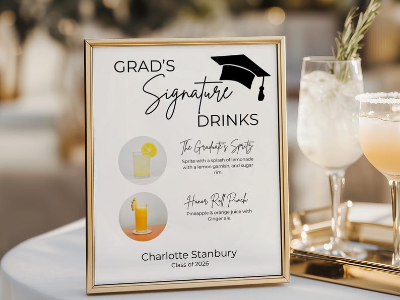 May include: A gold-framed sign titled Grad's Signature Drinks with a graduation cap icon. It lists The Graduate's Spritz and Honor Roll Punch with images of each drink. The bottom text reads Charlotte Stanbury Class of 2026 in black lettering.