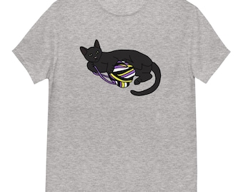 Op de afbeelding: Lichtgrijs t-shirt met een zwarte kat die speelt met een bol garen. De bol garen heeft paarse, gele en witte strepen. De kat ligt met zijn staart opgerold.