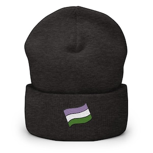 Könnte beinhalten: Dunkelgraue Beanie-Mütze mit umgeschlagenem Saum. Sie hat eine gestickte Genderqueer-Pride-Flagge in Lila, Weiß und Grün. Ein modisches Accessoire, um Identität auszudrücken.