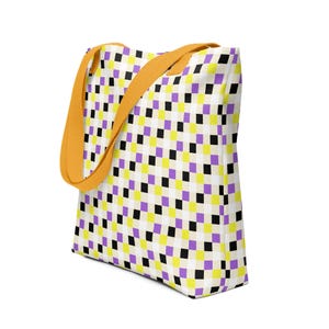 May include: A tote bag with a repeating pattern of black, yellow, and purple squares on a white background. The bag has orange straps.