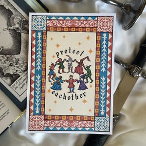 May include: A rectangular print featuring a central illustration of diverse figures in medieval attire holding hands in a circle, surrounded by the text "protect eachother" and gold stars, all enclosed within a decorative red and blue border.