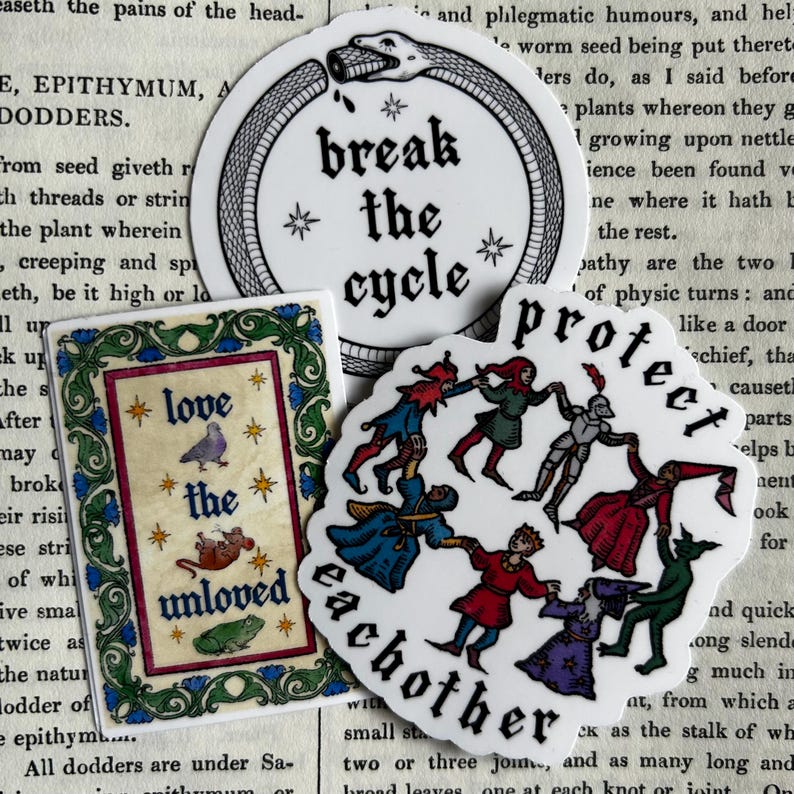 May include: Three stickers featuring illustrations and text. One circular sticker shows a snake eating its tail with the text "break the cycle". A rectangular sticker displays a pigeon, mouse, and frog with "love the unloved". A third sticker shows figures dancing with "protect eachother".
