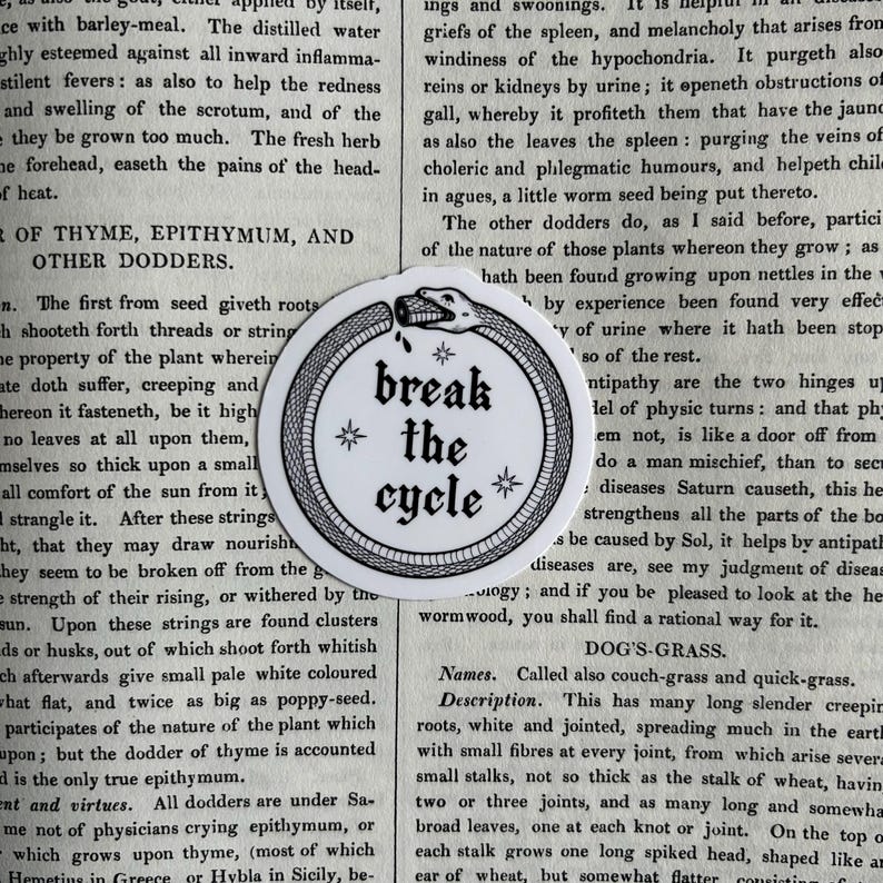 May include: A circular white sticker featuring a black line art illustration of an ouroboros snake eating its own tail. The center contains the black text "break the cycle" in a gothic font, accented by four small star symbols arranged around it.