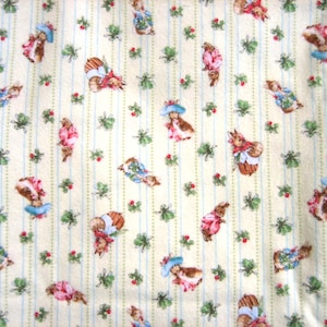 Puede incluir: Tela color crema con un patrón repetido de conejos con gorros y vestidos, intercalados con ramitas verdes y bayas rojas. Rayas verticales en azul claro y verde añaden una sutil textura de fondo. El diseño general tiene un aire vintage y caprichoso.