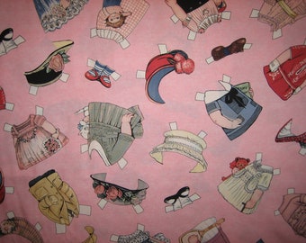 Könnte beinhalten: Rosa Papier mit verschiedenen Papierpuppen und Zubehör. Die Puppen sind in verschiedenen Outfits gekleidet, darunter ein Kleid mit Blumen, ein blaues Kleid mit weißem Kragen und ein rotes Kleid mit weißem Kragen. Das Zubehör umfasst einen Hut, ein Paar Schuhe und ein Buch.