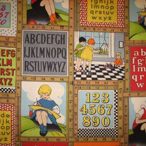 Op de afbeelding: Een kleurrijke stof met een herhalend patroon van alfabetletters, cijfers en kinderillustraties. De stof heeft een liniaal met inchmarkeringen, een meisje dat op een notitieblok tekent, een meisje dat een viskom vasthoudt en twee kinderen die op een schaakbordpatroon spelen.