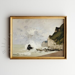 May include: A framed landscape painting depicts a coastal scene with crashing waves and cliffs. The artwork features a gold frame and a muted color palette of blues, greens, and browns. The painting evokes a sense of the sea and nature.