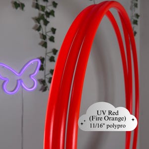 Puede incluir: Hula hoop UV rojo brillante hecho de polipropileno de 1,7 cm. El aro es de un vibrante color naranja fuego. Un fondo de neón púrpura mariposa.