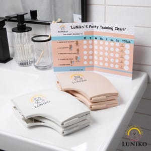 May include: A white and beige potty training chart and seat set. The chart reads "LuNiko's Potty Training Chart" and includes a reward system. The seats are curved and feature the "LuNiko" logo with a bear and sun design.